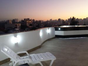 un banco blanco sentado en el techo de un edificio en Duplex de Cinema!! en Porto Alegre