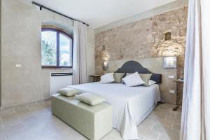- une chambre avec un grand lit et un mur en pierre dans l'établissement Casa Vendicari Boutique Hotel, à Noto