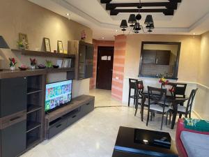 un soggiorno con TV e una sala da pranzo di Appartements Marrakech Garden a Marrakech