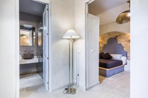 1 dormitorio con 1 cama, lavamanos y lámpara en Casa Vendicari Boutique Hotel en Noto