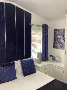 een slaapkamer met een bed met blauwe gordijnen en een raam bij Silver oaks lodge in Felton