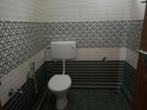 a bathroom with a toilet and black and white tiles at Bethel Service Villa, Mananthavady, Wayanad in Wayanad