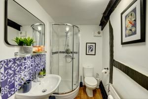 y baño con ducha, lavabo y aseo. en Loft Cottage by Spa Town Property - 2 Bed Tudor Retreat Near to Stratford-upon-Avon, Warwick & Solihull, en Stratford-upon-Avon