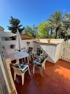 un patio con mesa, sillas y sombrilla en VILLA MARE - 2 beds with balcony, patio and pool and direct park access, en Murcia