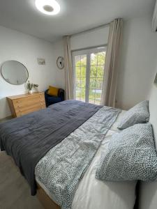 Un dormitorio con una cama grande y una ventana en VILLA MARE - 2 beds with balcony, patio and pool and direct park access, en Murcia