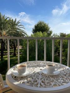 2 tazas de café sentadas en una mesa en un balcón en VILLA MARE - 2 beds with balcony, patio and pool and direct park access, en Murcia