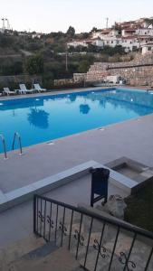 una gran piscina con una silla frente a ella en Semiramis Garden, en Milas