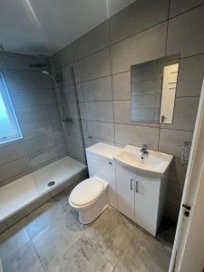 ein Badezimmer mit einem WC, einem Waschbecken und einer Badewanne in der Unterkunft Clydebank Apartment in Glasgow