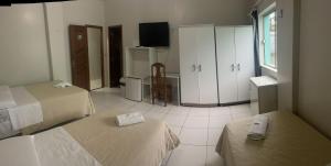 um quarto de hotel com duas camas e uma televisão em Hamara Soft Hotel 1 em Altamira