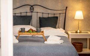 łóżko z tacą z jedzeniem oraz 2 kubkami i ręcznikami w obiekcie 2HomeRent Emily w mieście Sopot