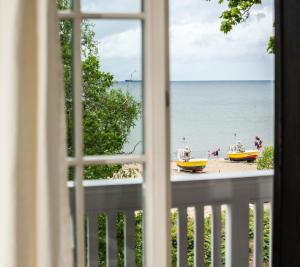 a window view of a beach with boats in the water at 2HomeRent Emily in Sopot