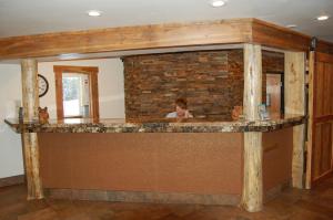 a woman standing behind a bar in a house at Kelly Inn West Yellowstone in West Yellowstone