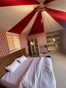 a bedroom with a bed with a red and white ceiling at Wadi rum Ahmed Badawi in Wadi Rum
