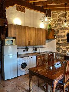 a kitchen with a table and a washer and dryer at El Balconcillo del Alberche in Navaluenga