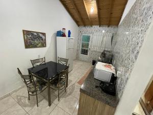 uma cozinha com uma mesa e uma pequena mesa e cadeiras em Casa grande com Piscina e Churrasqueira em Bonito