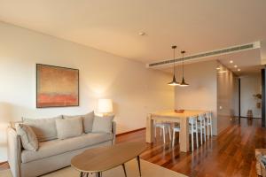 a living room with a couch and a table at Tróia Resort Beach Villa in Troia