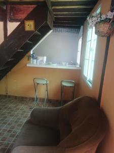 una sala de estar con 2 taburetes en una habitación en Coffee Store La Cabaña, en Valle Hornito
