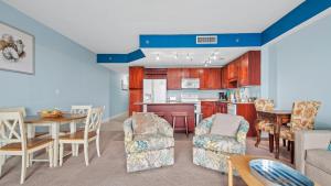 ein Wohnzimmer mit einem Tisch und Stühlen sowie eine Küche in der Unterkunft Laketown Wharf #113 by Nautical Properties in Panama City Beach