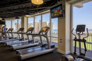 a row of treadmills in a gym with windows at Laketown Wharf #113 by Nautical Properties in Panama City Beach