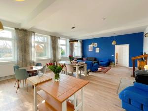 sala de estar con mesa y pared azul en Landhof in Ganschendorf, Landhaus Seenah en Sarow