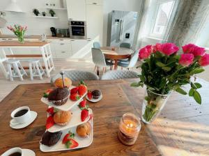 einen Tisch mit drei Teller Cupcakes und Erdbeeren in der Unterkunft Landhof in Ganschendorf, Landhaus Seenah in Sarow