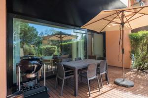 a patio with a grill and a table and chairs at Tróia Resort Beach Villa in Troia