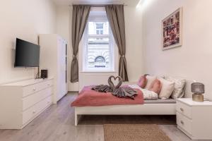 - une chambre blanche avec un lit et une fenêtre dans l'établissement Goldcentral Apartment Comfort, à Budapest
