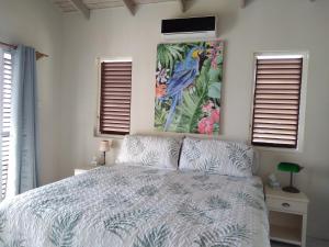 a bedroom with a bed and a painting on the wall at Seascape Villa 3BR with Stunning Caribbean Sea View in Castries