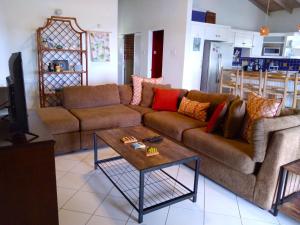 a living room with a couch and a coffee table at Seascape Villa 3BR with Stunning Caribbean Sea View in Castries