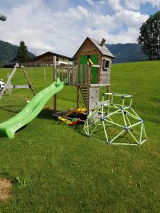 un parque infantil con tobogán y una casa de juegos en Appartements Real en Schladming