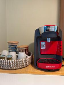 a red and black toaster next to a basket of cups at Αγκυροβόλιο in Ilia