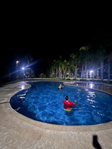 une personne dans une piscine la nuit dans l'établissement Finca San José los Naranjos, à Santa Marta