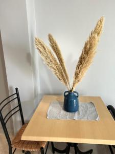 a table with a blue vase with feathers in it at Αγκυροβόλιο in Ilia
