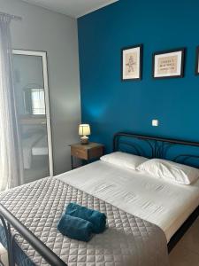 a blue bedroom with a bed with a blue wall at Αγκυροβόλιο in Ilia