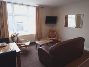 a living room with a couch and a chair at Pier View Apartments by Pillow Partners in Skegness