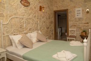 a bedroom with a white bed with a green blanket at La casa de Ioanna in Kissamos