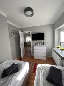 a bedroom with two beds and a flat screen tv at FineApartment Borgstedt in Borgstedt