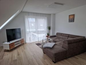 a living room with a couch and a flat screen tv at New & Modern Apartment near Düsseldorf in Willich