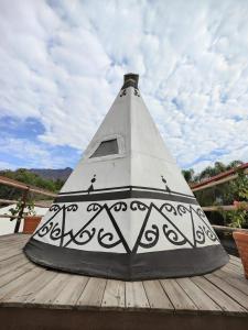 a black and white bird house on a wooden deck at Fungi Tipis in Tepoztlán