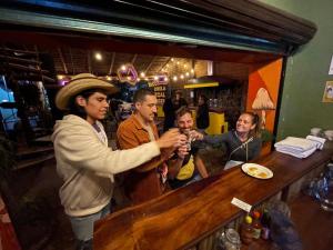 un grupo de personas de pie alrededor de un bar en Fungi Tipis, en Tepoztlán