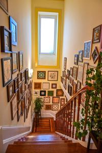 una escalera con un montón de cuadros en la pared en Vintage Balcony Guesthouse, en Ovar