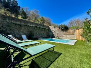 une arrière-cour avec une piscine et deux chaises longues dans l'établissement Jardin de la Garrigue - Maison 160m2 - Piscine, à Aragon