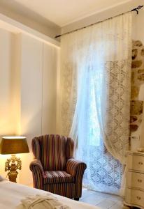 ein Schlafzimmer mit einem Bett, einem Stuhl und einem Fenster in der Unterkunft Itaca Home to Explorers in Polignano a mare in Polignano a Mare