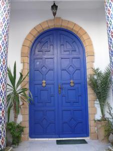 una puerta azul en un edificio con plantas en Taghart, la belle demeure, en Essaouira