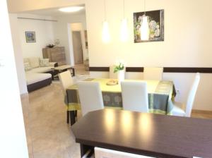 a dining room and living room with a table and chairs at Solemio Apartman Kalocsa in Kalocsa