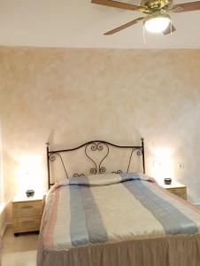 um quarto com uma cama e uma ventoinha de tecto em Villa Loma em Belicena