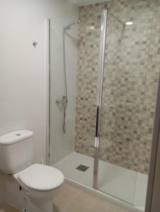 a bathroom with a toilet and a glass shower at Villa Loma in Belicena