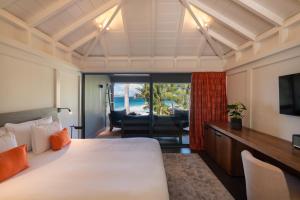 a hotel room with a bed and a view of the ocean at Hotel Christopher Saint Barth in Gustavia