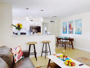 een woonkamer met een bank en een tafel met fruit bij Coco Palms Apartments By Lowkl in Lighthouse Point