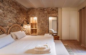 a bedroom with a bed and a stone wall at La Comuna by Bon Dia Residences in Girona